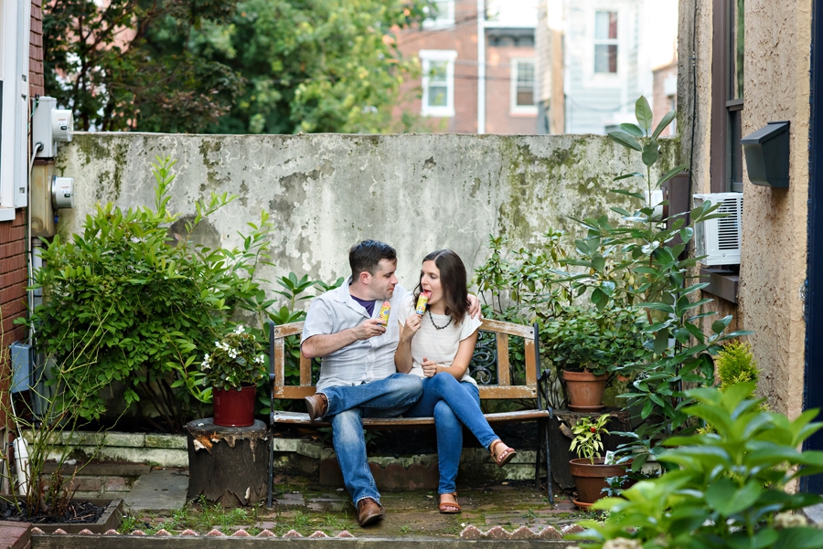 A cute couple enjoy ice cream while sitting on a bench outside of their house in fishtown.